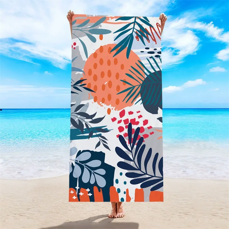 Colorful printed beach towel held against the sea